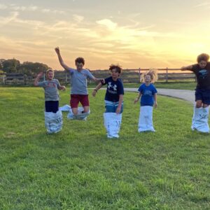 photo Racing Against the Sunset - A group of 4H kids were having a sack race with old pig feed bags. Their excitement with the beautiful sunset behind them was picture perfect!  What a beautiful picture of Kinder and the youth that help make it great.  Taken August 22, 2023 by Juli Railsback
