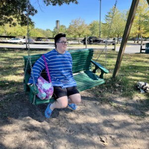 photo Pure Joy - Submitted in loving memory of Wren. This photo was taken on October 11, 2024, of Wren on the swing. It represents a depiction of Autistic Joy caused by sensory overload in the happy way. Orion says that being married to an autistic individual is a gift.  We wouldn't have it any other way. by Orion Romero & Wren Spates