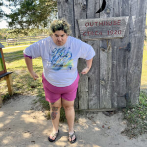 photo Shrek Impersonation - Submitted in loving memory of Wren. This photo taken on October 11, 2024, by Wren, shows Orion impersonating an ogre because the outhouse reminded us of the one from the movie Shrek. by Orion Romero & Wren Spates